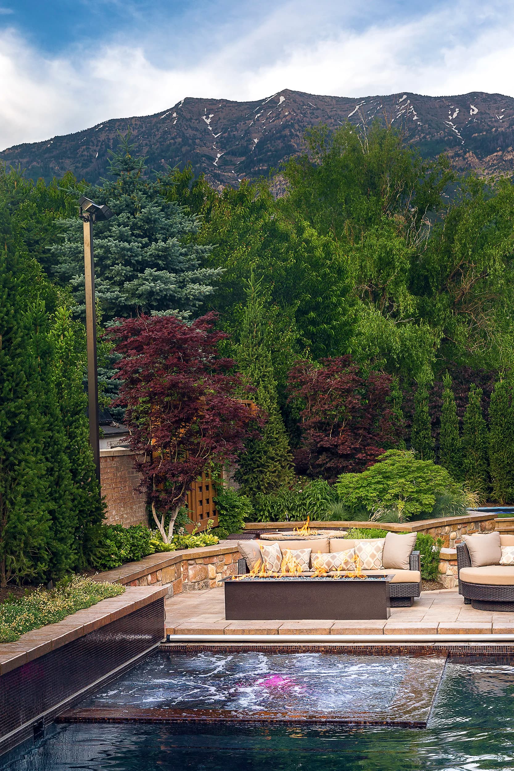 Mature, professionally maintained modern Big Rock landscape with crisp turf, sculpted plantings, and Wasatch mountain backdrop