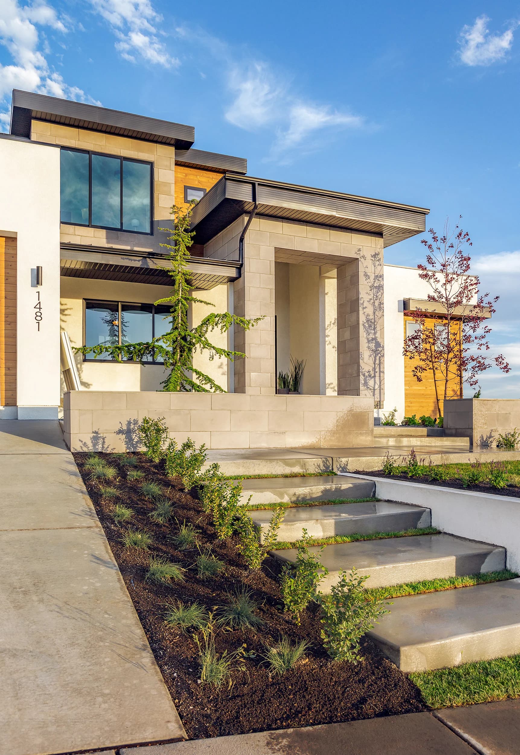 Modern Big Rock front entry with floating concrete steps, drought-tolerant plantings, and sandstone facade